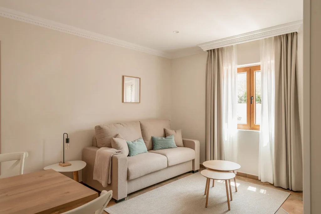Salón-comedor con sofá cama y televisión en apartamento