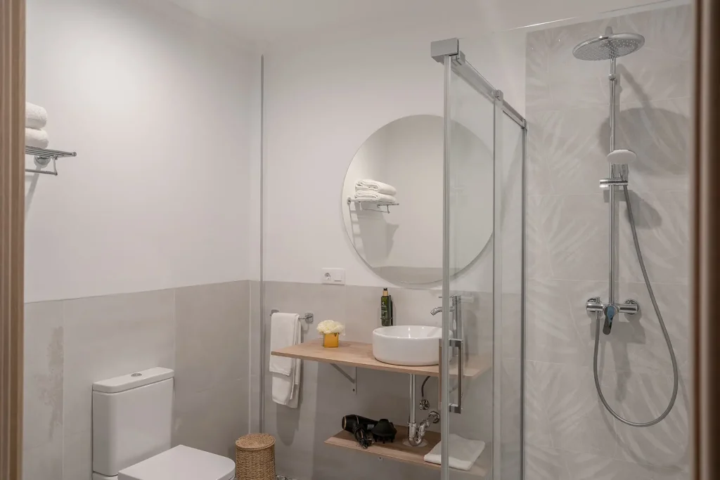 Detalle del baño moderno con ducha y accesorios incluidos