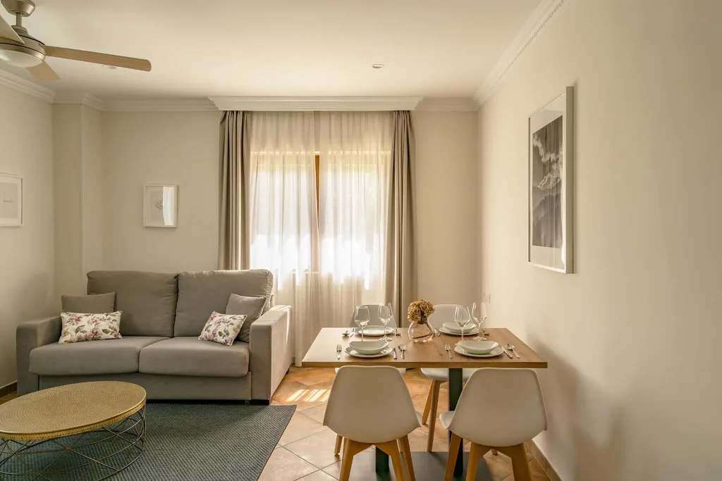 Salón-comedor con sofá cama y televisión en apartamento de 3 personas