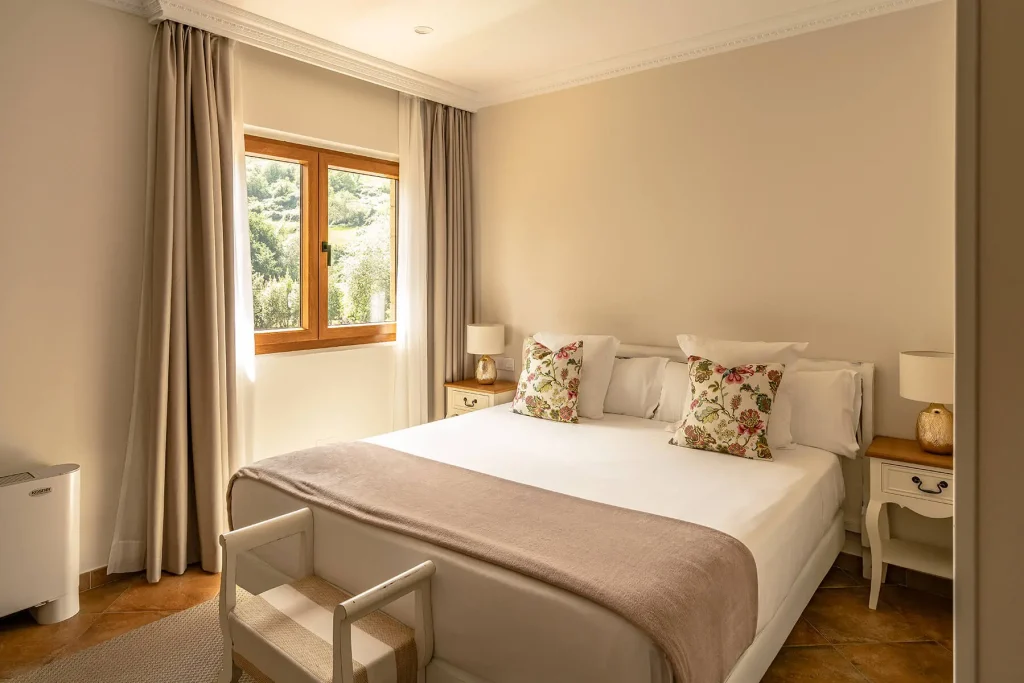 Dormitorio con cama doble de 150 cm y vistas al entorno natural