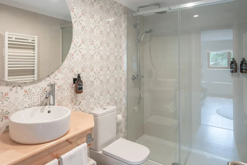 Detalle del baño moderno con ducha y accesorios incluidos